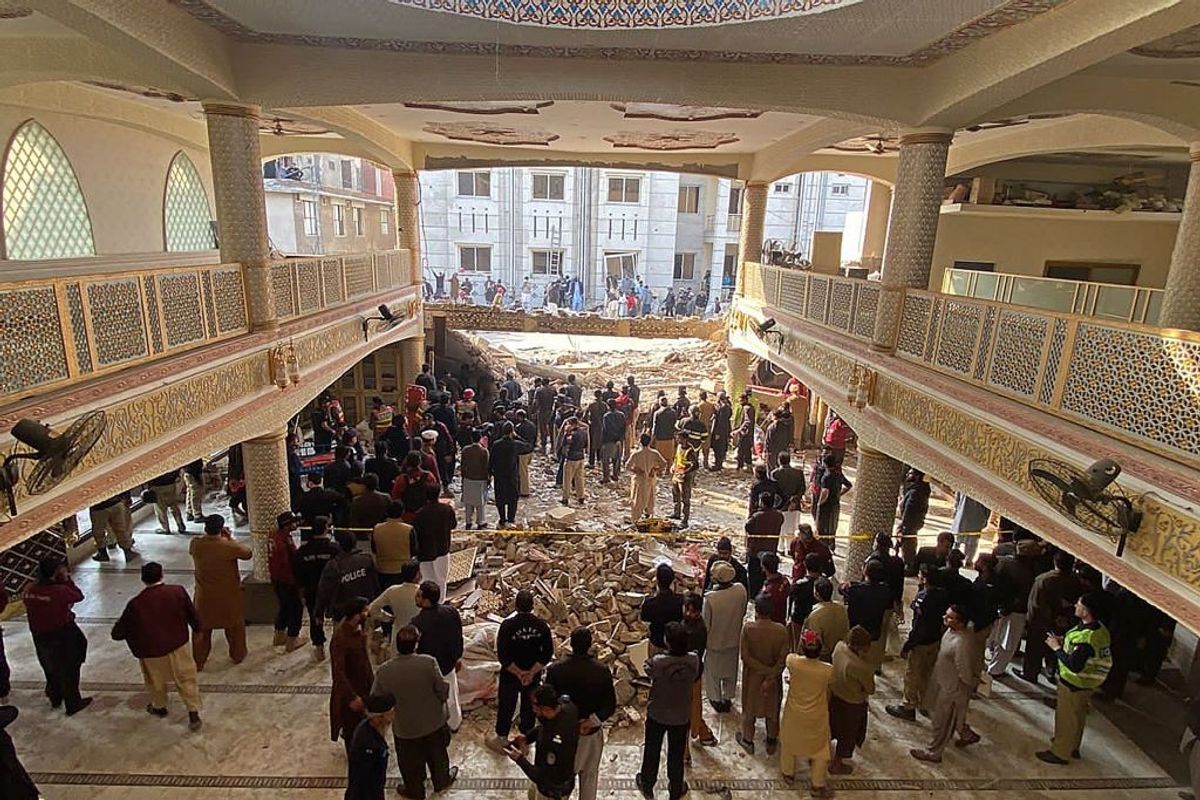 Security officials inspect the site of a mosque in Peshawar in Pakistan
