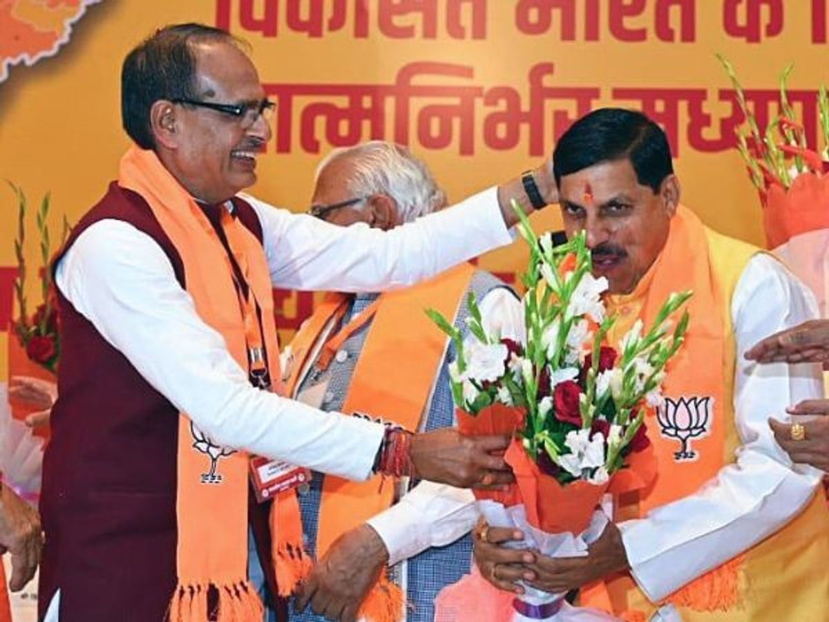 Shivraj Singh Chouhan (L), the outgoing chief minister of the central Indian state of Madhya Pradesh, greets newly elected CM Mohan Yadav during the Bharatiya Janata Party (BJP)'s legislature party meeting, at party headquarters in Bhopal