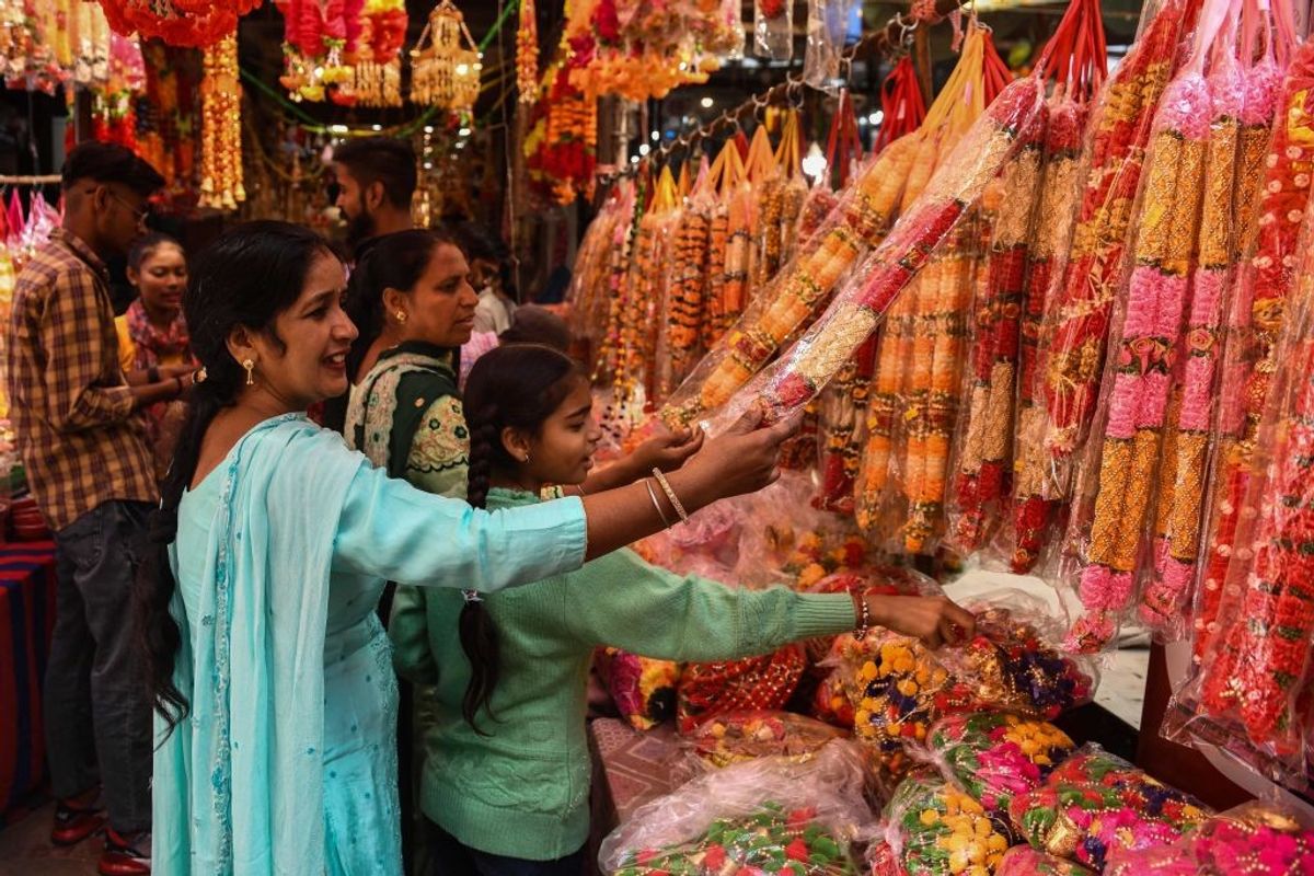 Shoppers buy artificial flower garlands ahead of the Hindu festival of Diwali