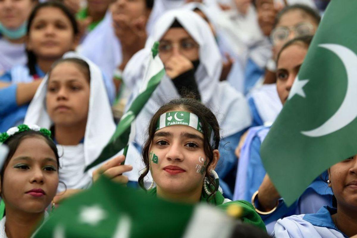 Students wave Pakistan's national flags at the mausoleum of the country's founder Mohammad Ali Jinnah, during Pakistan's Independence Day celebrations in Karachi