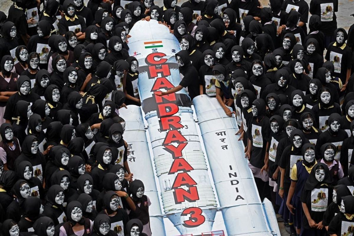 Students with painted faces surround a replica of the Chandrayaan-3 spacecraft in Chennai in the southern state of Tamil Nadu