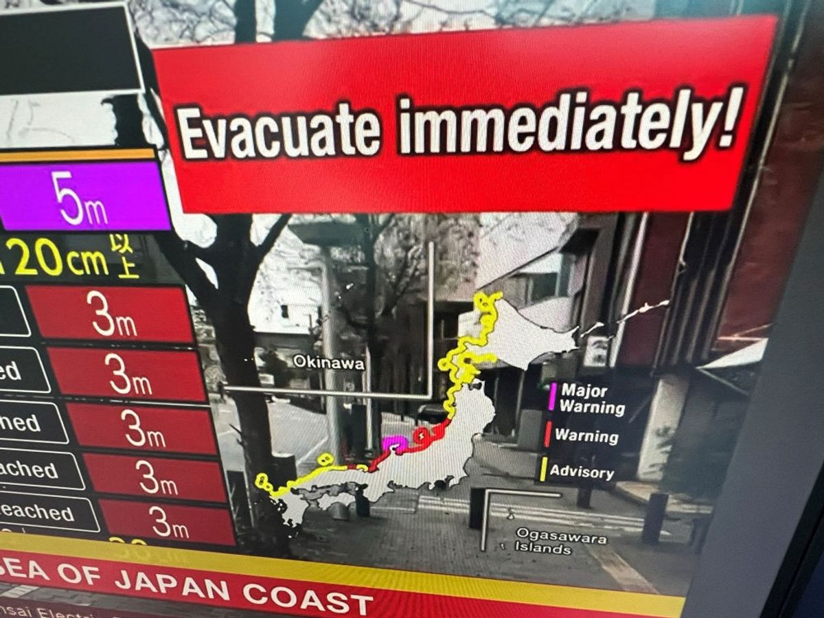 This image taken in Hong Kong on January 1, 2024, shows a warning message on a screen from a live feed on NHK World asking people to evacuate from the area after a series of major earthquakes hit central Japan