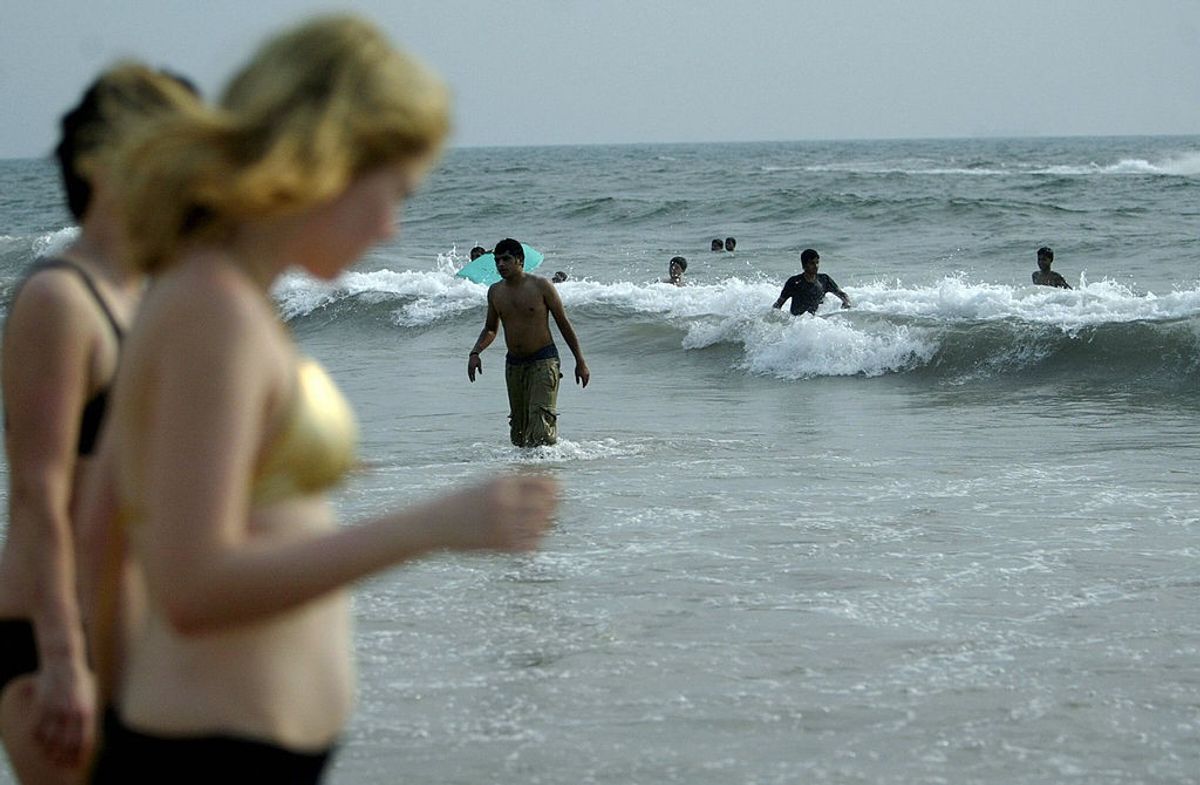 Tourists relax at Baga beach in Goa