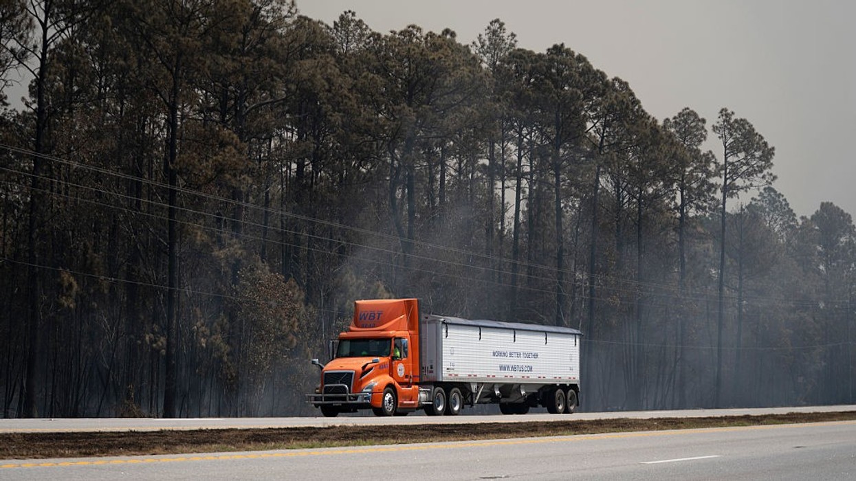 Truck driver passes smoldering remnants of the Brantley Highway 82 Fire