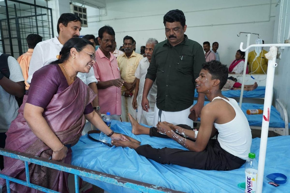 Veena Geroeg (L), the health minister of the southern Indian state of Kerala, speaks to a person injured in the blasts at the convention centre in the southern state, on Sunday.