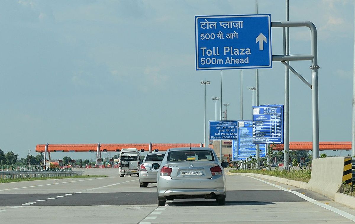 Vehicles arrive at a toll plaza on an Indian highway.