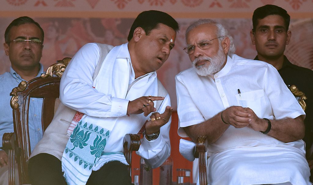 Indian prime minister Narendra Modi speaks with ports minister Sarbananda Sonowal