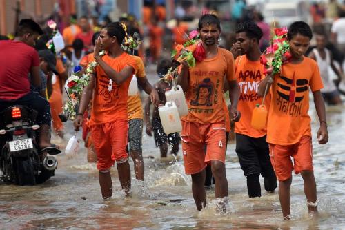 Hindu devotees of Lord Shiva carrying water from the River Ganges in containers as a part of a ritual amid the rising water levels in Prayagraj in Uttar Pradesh on August 5, 2021. ( (Photo by SANJAY KANOJIA/AFP via Getty Images)