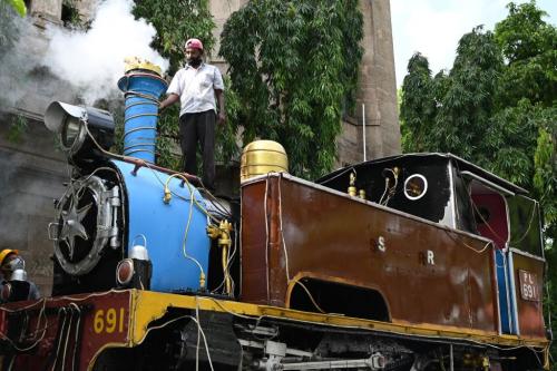 Workers perform restoration work on a 1903 steam locomotive PL 691 kept on display at southern railway headquarters in Chennai, Tamil Nadu, on August 6, 2021. (Photo by ARUN SANKAR/AFP via Getty Images)