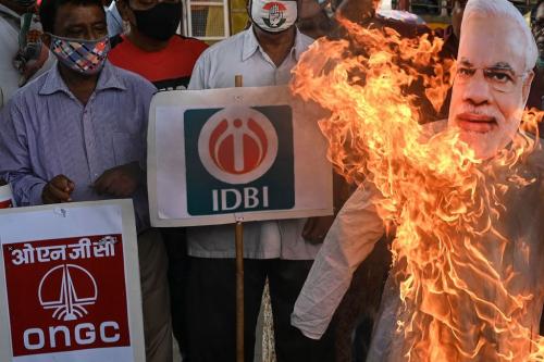 Members of the opposition Indian National Congress with logos of different public sector enterprises shout slogans and burn an effigy of Indian prime minister Narendra Modi to protest the government's economic policies in Kolkata in West Bengal on August 9, 2021. (Photo by DIBYANGSHU SARKAR/AFP via Getty Images)
